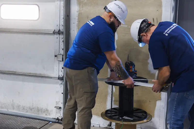 two male construction workers with hard hats working with tools