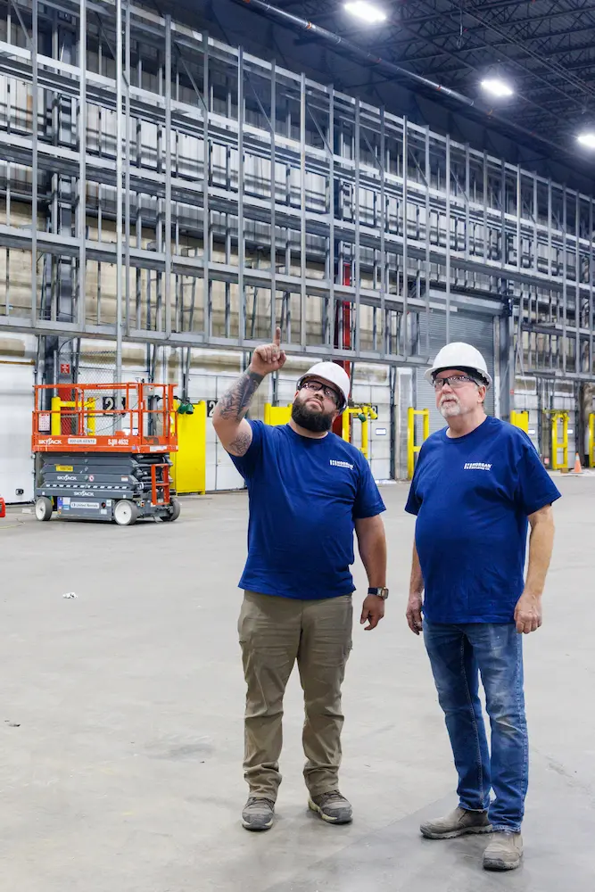 two construction workers with hard hats in a large site