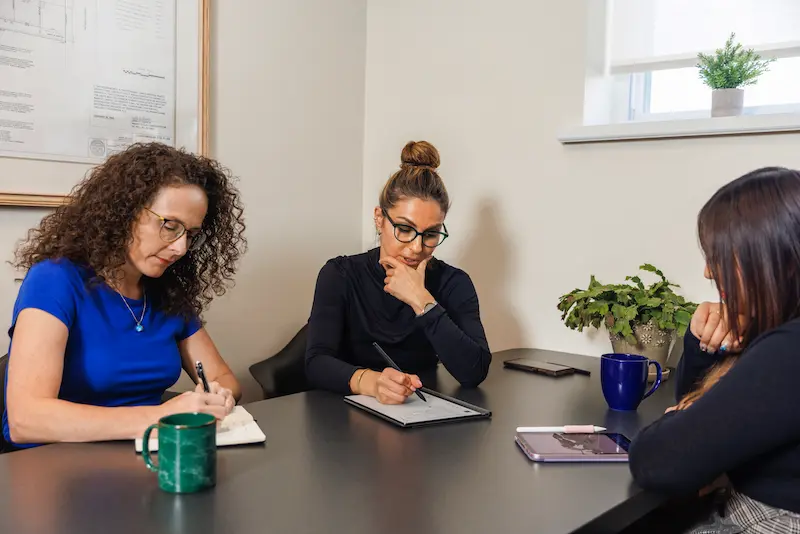 women sitting around a table discussing a project