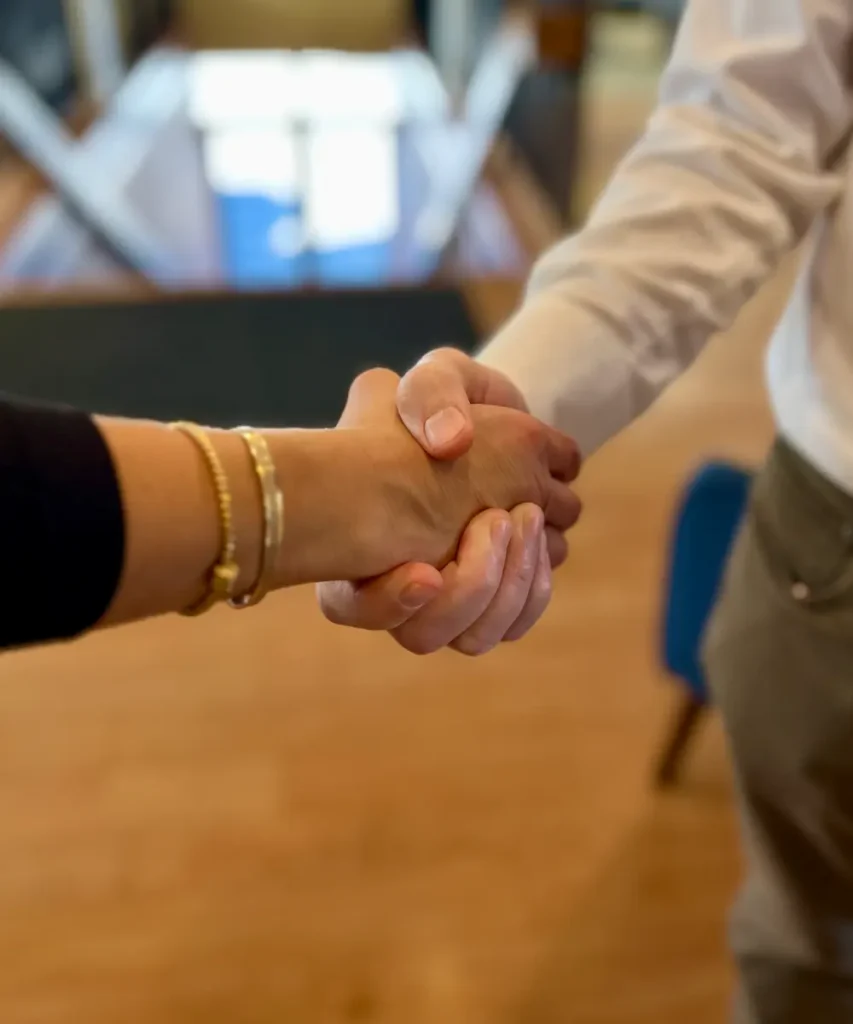 a man and woman shaking hands in a modern office