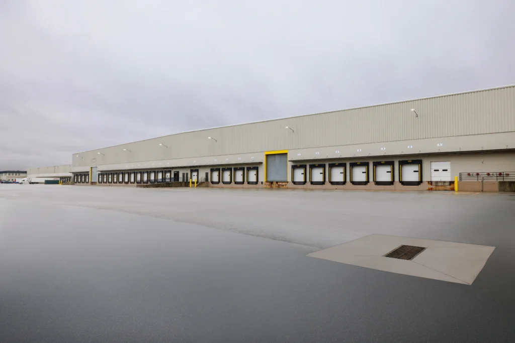 exterior of warehouse with many loading dock garage doors framed in brown