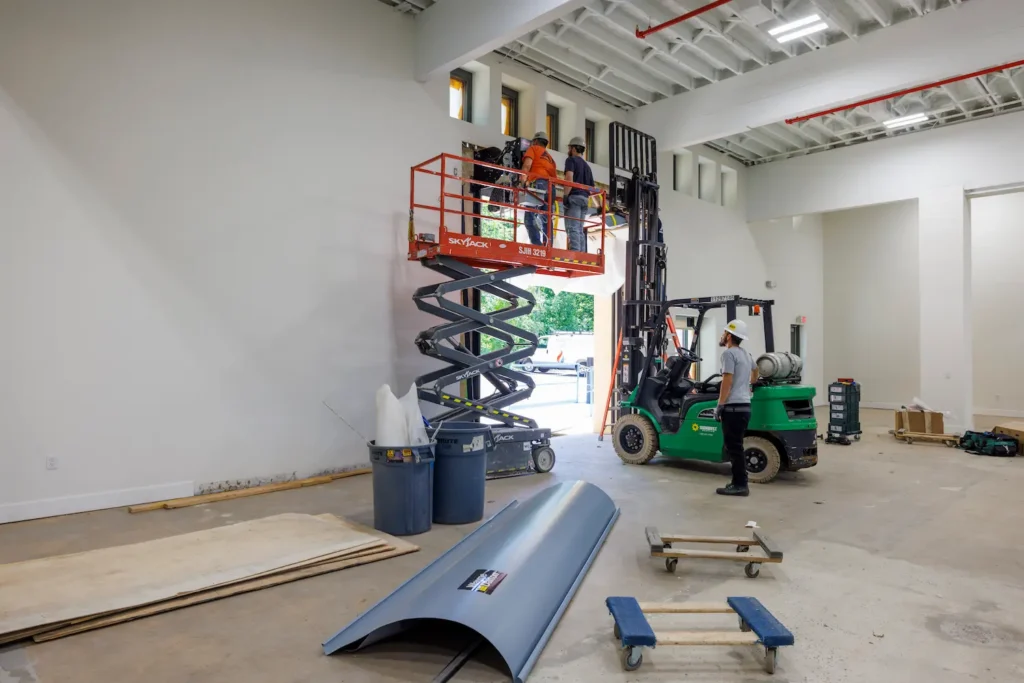 Horgan construction team on a lift building a loading dock door on the inside of a warehouse building