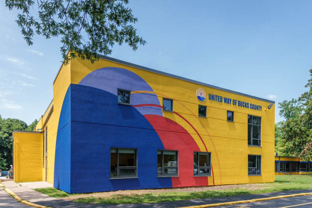 The front of the United Way building shown in bright colors of red, yellow and blue